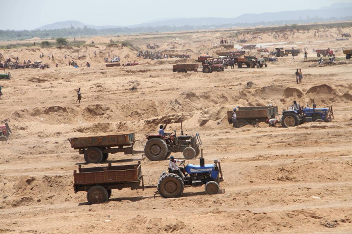 Open sand mining in Chambal River with trucks and loaders operating illegally