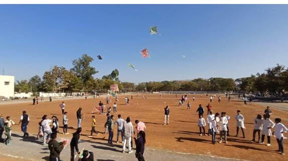 Participants flying colorful kites at the Katni Kite Festival, with a focus on themes of cyber security, women's and children's safety, and road safety.