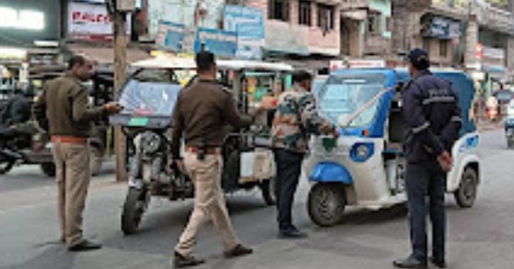 Katni traffic police taking action against an e-rickshaw, with officers engaged in traffic control duties in an urban setting.