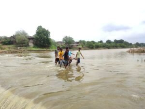 Villagers crossing overflowing river on weak culvert in Harangaon, Barwani, after administration ignored complaints.