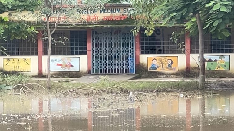 Flooded government English medium school in Dhamnod, Dhar, with waterlogged classrooms and children affected.