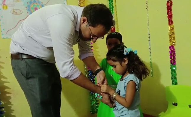 Collector Ashish Tiwari receives Rakhi from young girls at Dithwara Anganwadi in Katni